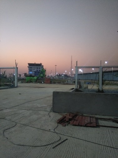 Ground works at dusk beside the Payra Port road, with street lighting beyond